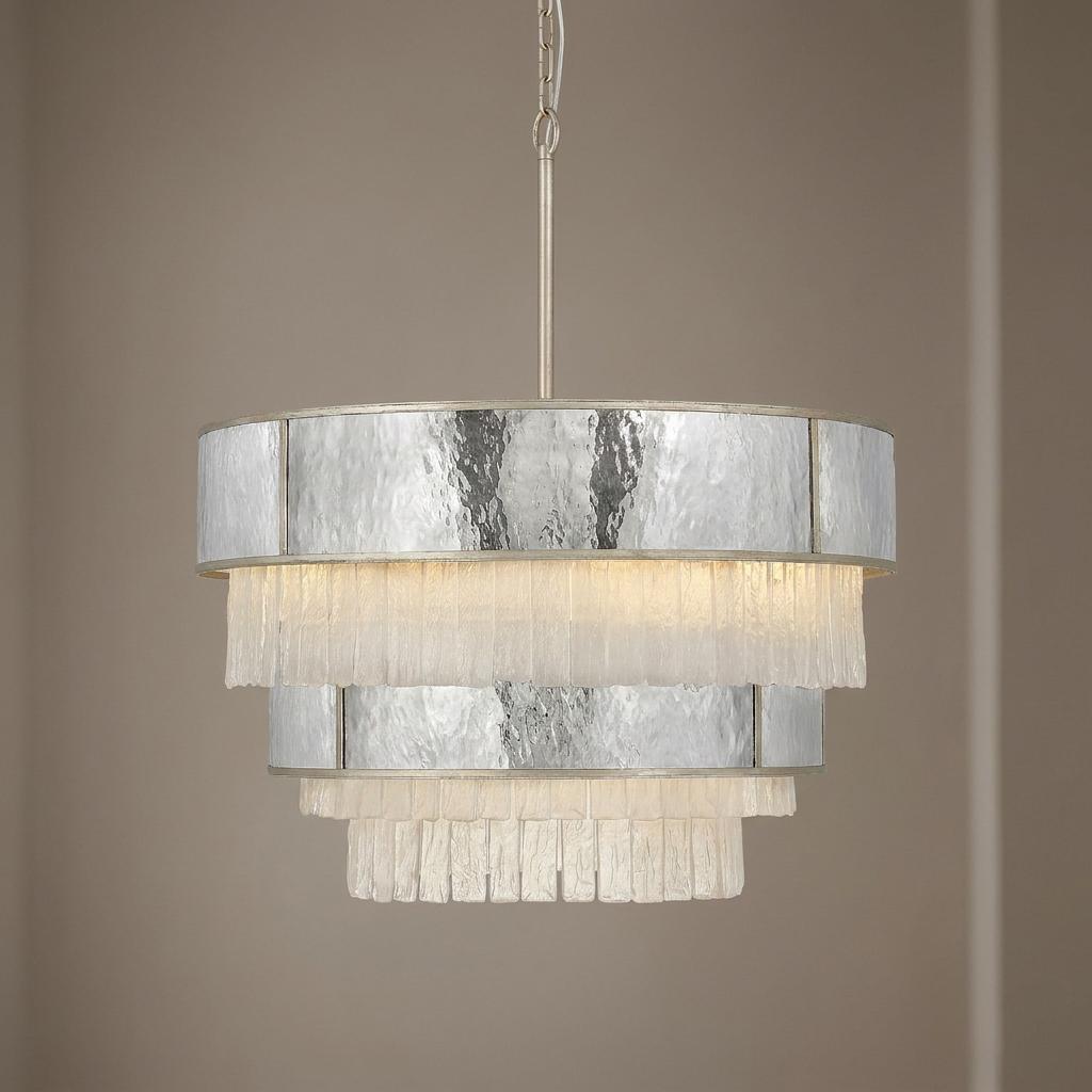 Reverie 12-light gold pendant with alternating tiers of textured glass and hammered metal against a neutral wall.