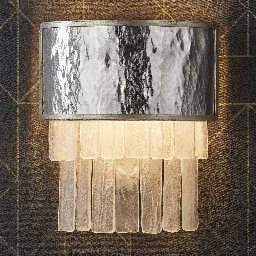 A Reverie 2 Light Gold Wall Light with textured glass panels and tiered rods mounted on geometric patterned wallpaper.