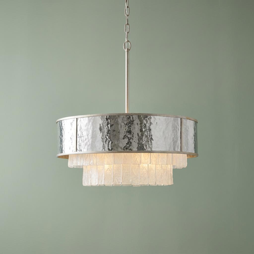 Modern gold pendant light featuring a hammered metal band and textured glass tiers against a muted green wall.