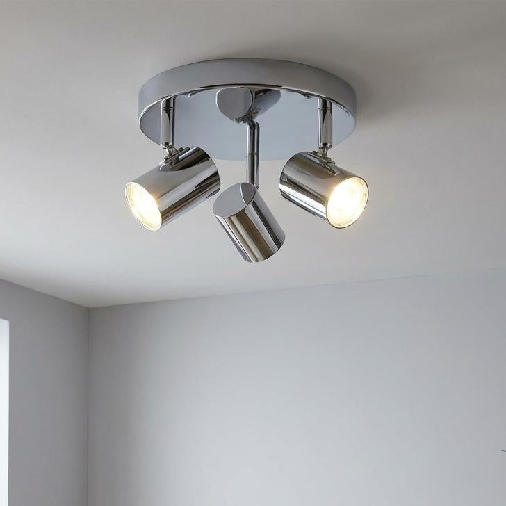 Rollo 3 light chrome cylinder head flush spotlight mounted on a white ceiling in a modern minimalist living room.