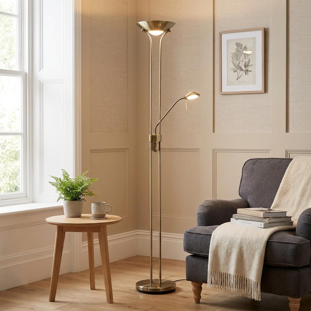 Rome Antique Nickel Mother & Child Floor Lamp lit in a cozy living room corner next to a grey armchair.