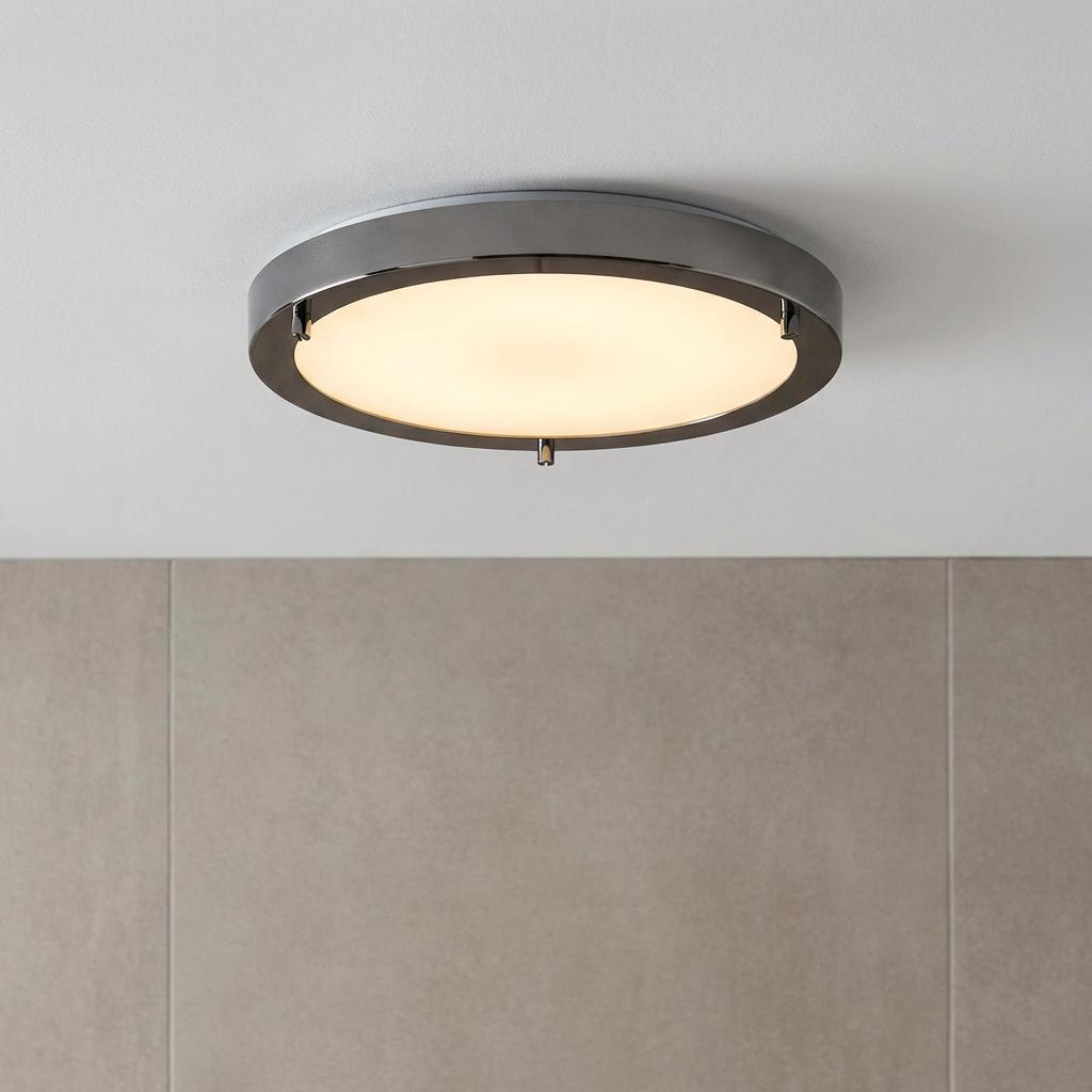 Modern circular flush bathroom ceiling light with a dark metallic frame and glowing frosted glass on a white ceiling.
