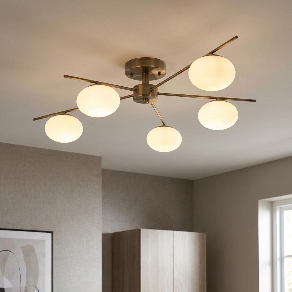 Antique brass semi-flush ceiling light with five opal glass globe shades on slender metal arms.