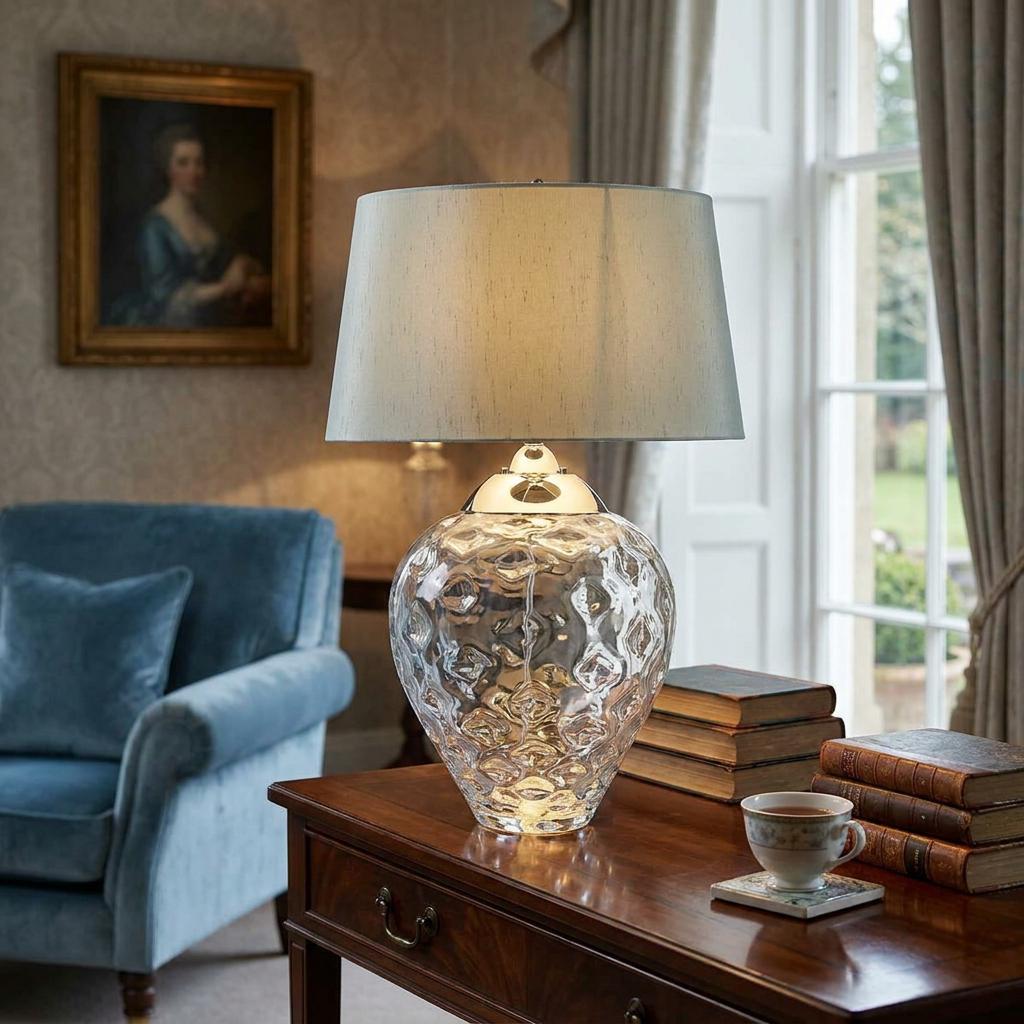 Samara Large Clear Glass Table Lamp with a textured base and grey shade on a wooden desk in a traditional room.