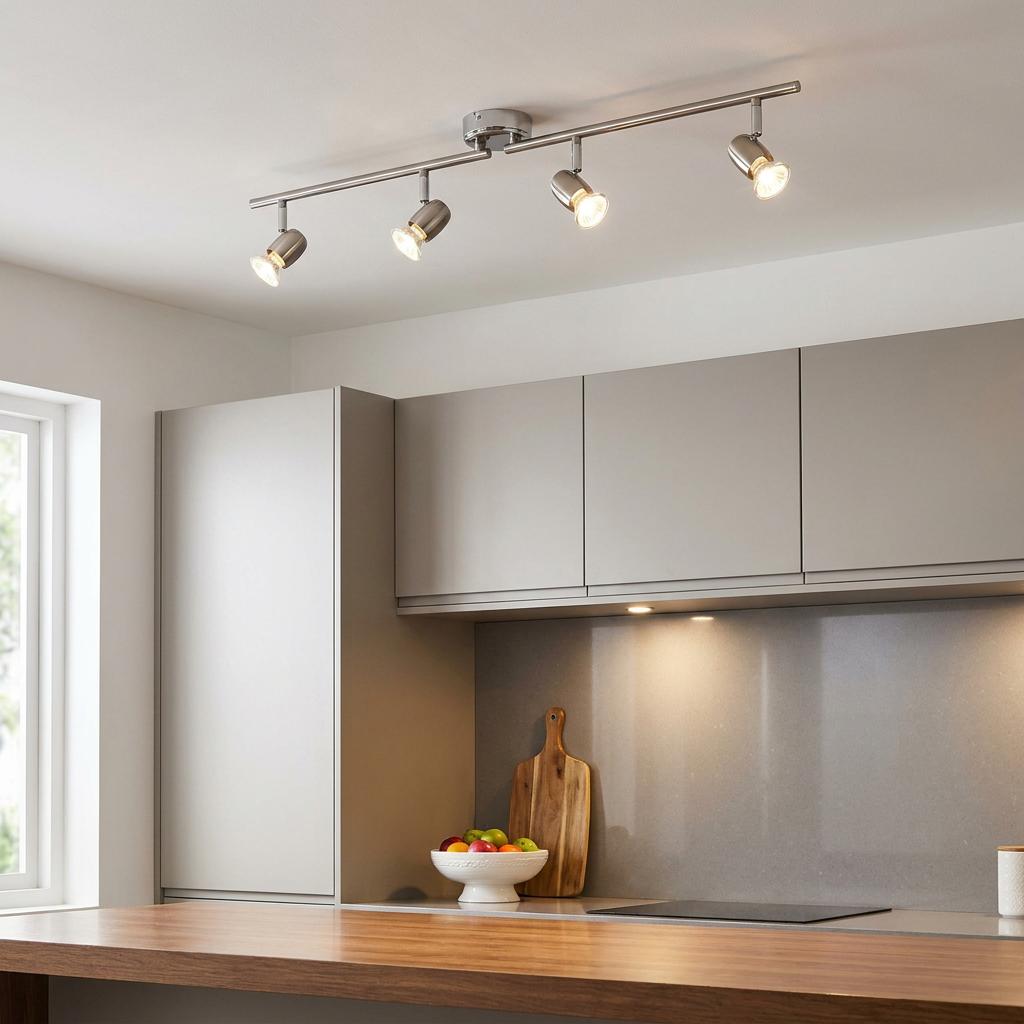 Brushed chrome 4-light ceiling spotlight bar illuminating a modern grey and wood kitchen.