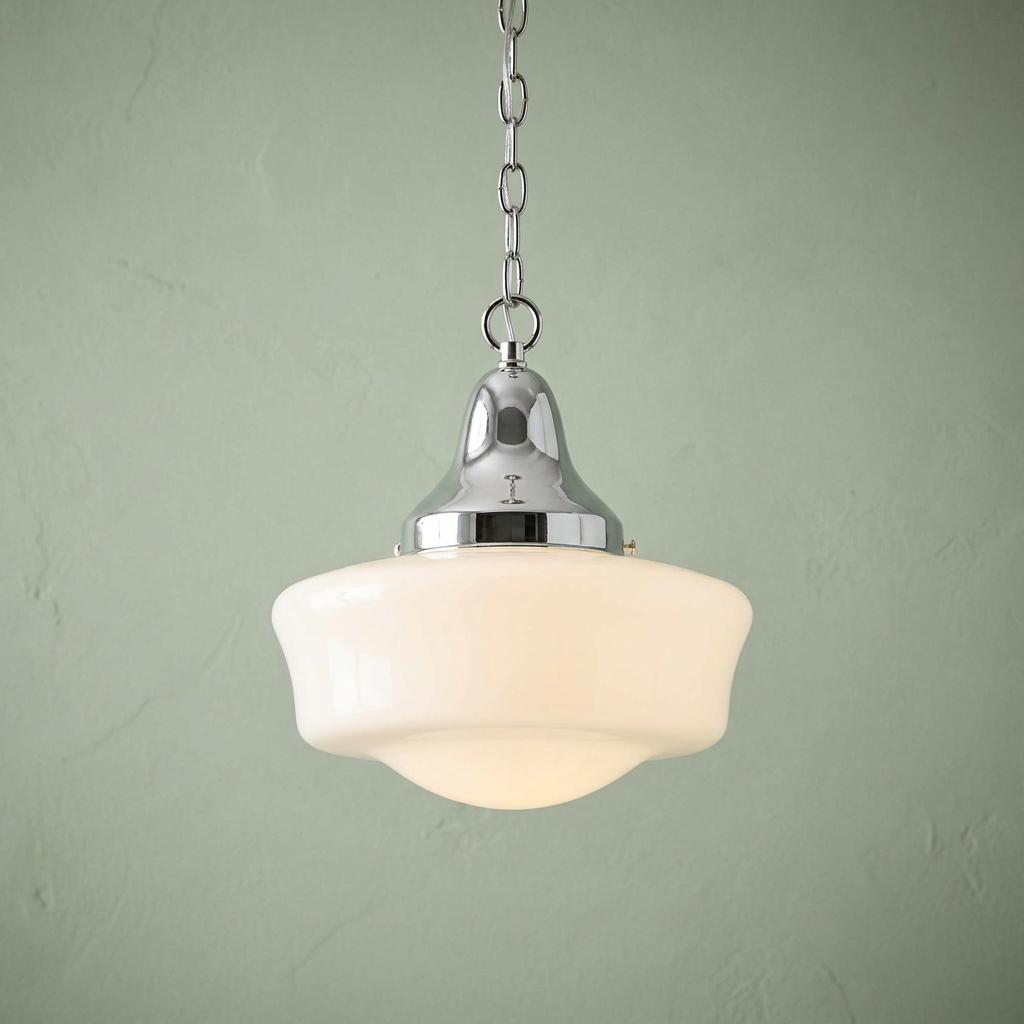 Art Deco schoolhouse pendant light with a white opal glass shade and chrome chain against a light green wall.