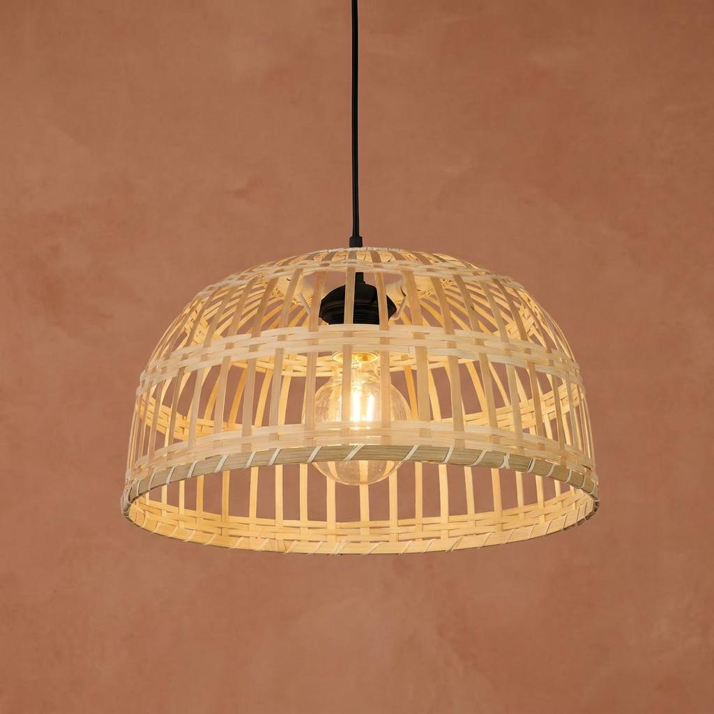 Searchlight Bali woven bamboo dome pendant light shade with a warm bulb against a terracotta background.