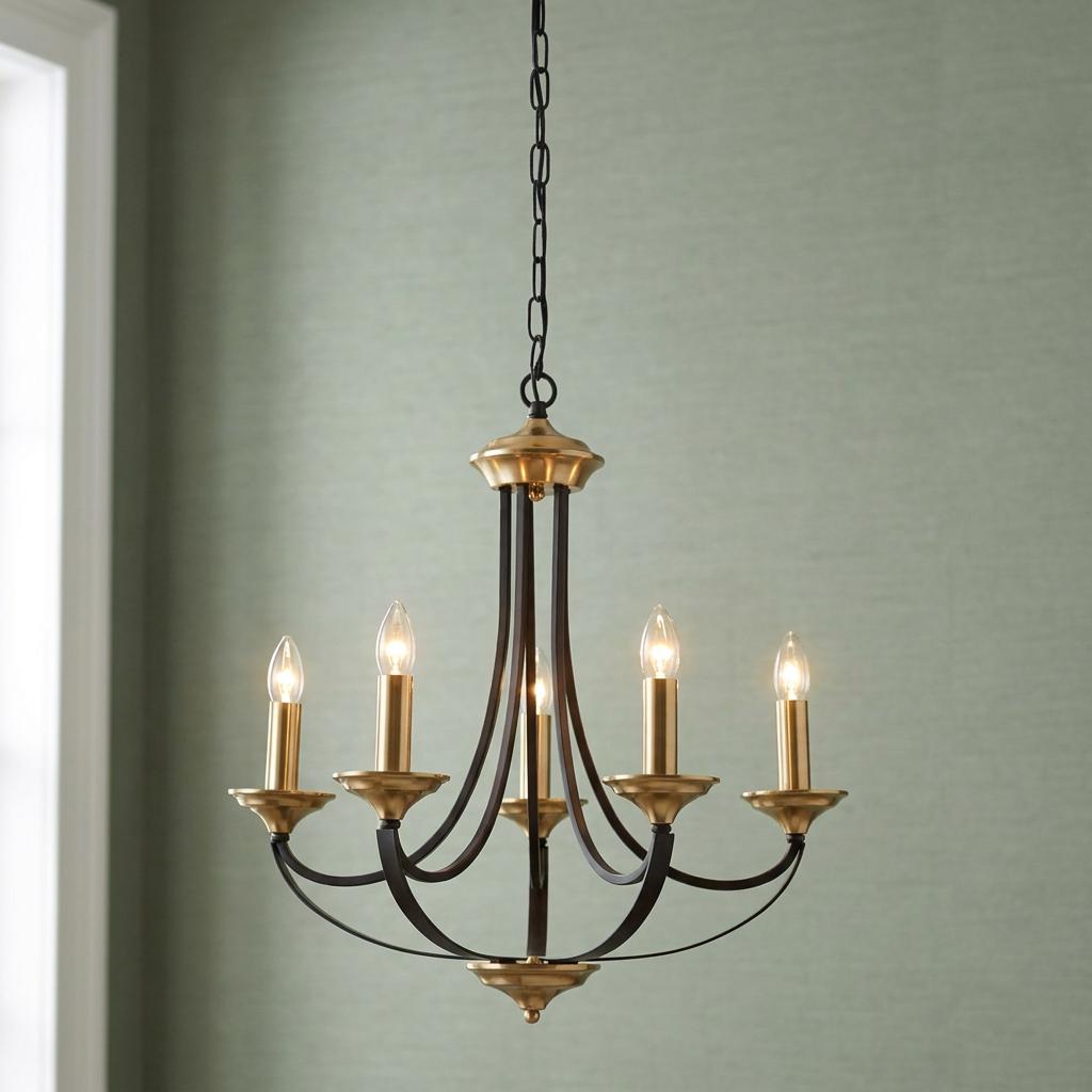 Searchlight Belfry five-light bronze and brass chandelier with candle bulbs against a textured sage green wall.