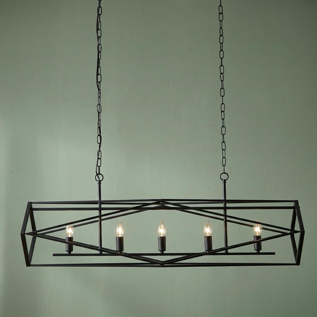 Black geometric cage 5-light pendant with candle bulbs suspended by chains against a light green background.