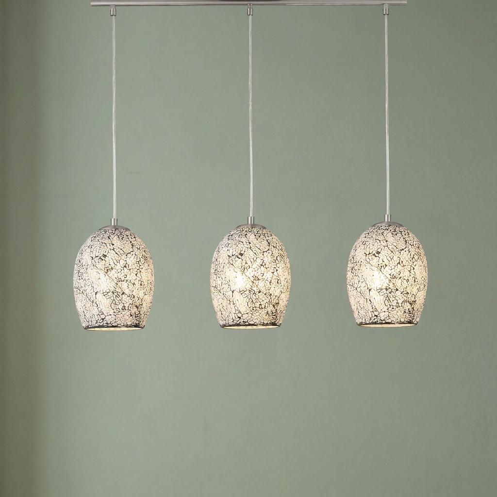 Three Searchlight Crackle pendant lights with white mosaic glass shades hanging in a row against a green wall.