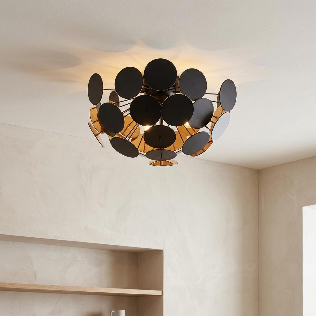 Modern semi-flush ceiling light with black and gold discs mounted on a white ceiling in a neutral room.