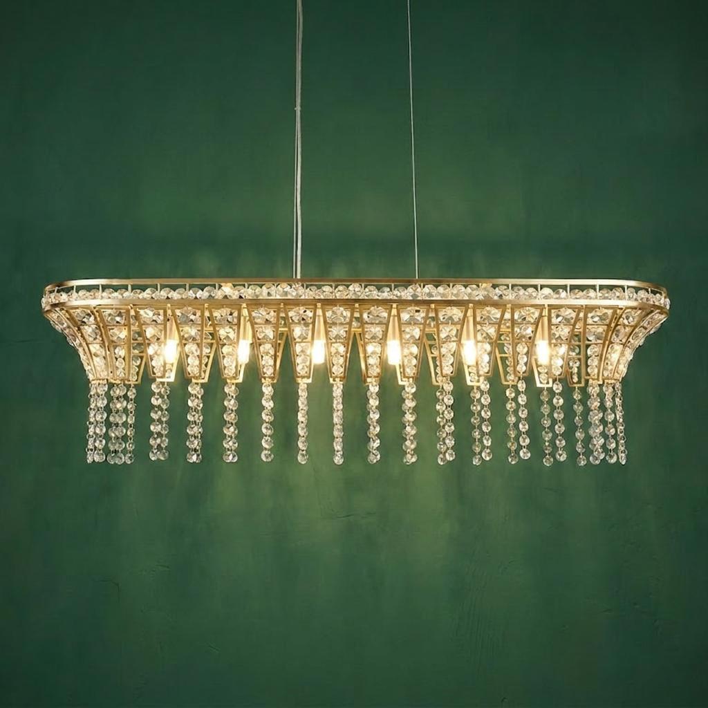 Gemma 8-light brass pendant with cascading crystal drops hanging against a textured deep green wall.