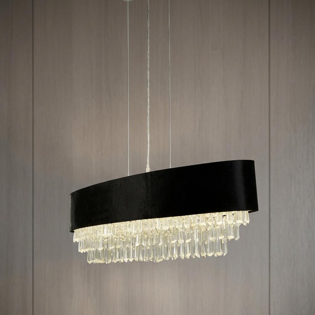 Modern oval black velvet pendant light with cascading crystal droplets hanging against a neutral paneled wall.