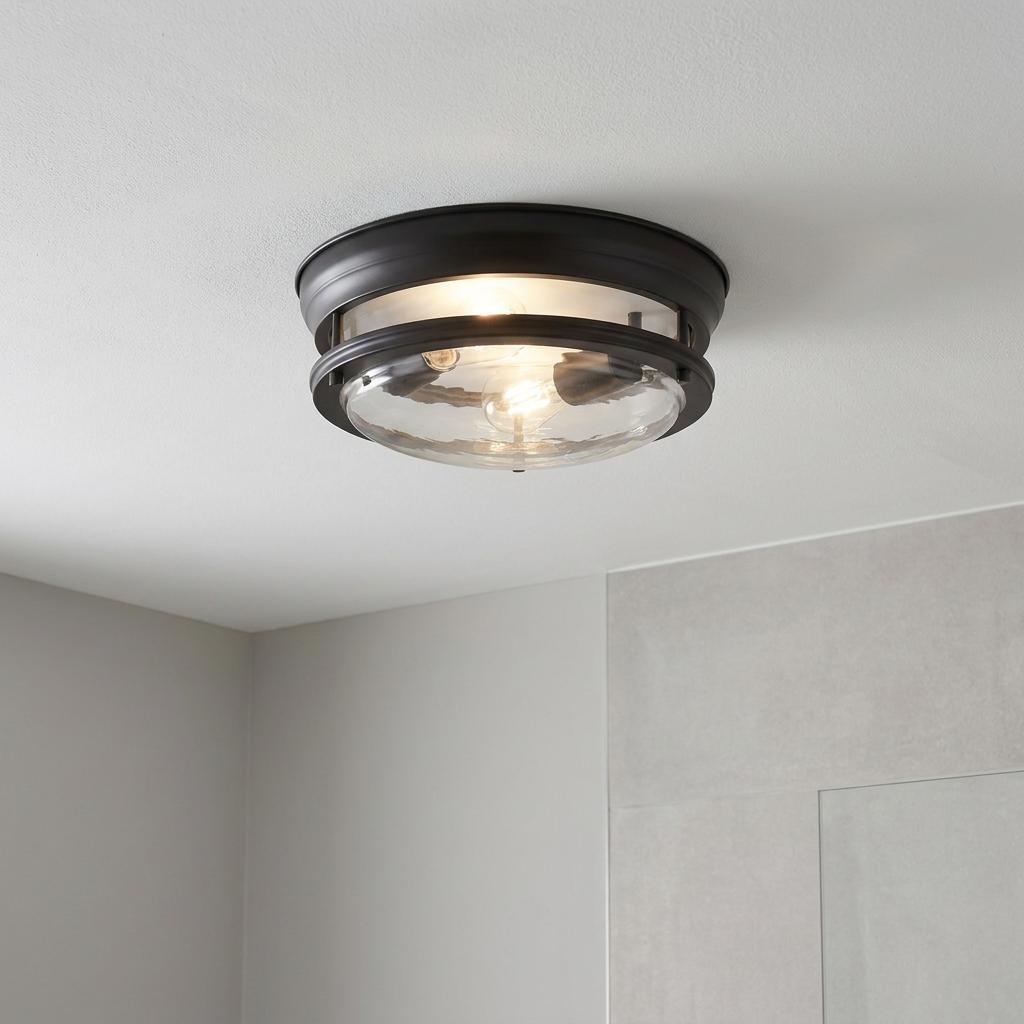 Two-light black flush ceiling fixture with a clear glass shade illuminating a neutral-toned room.