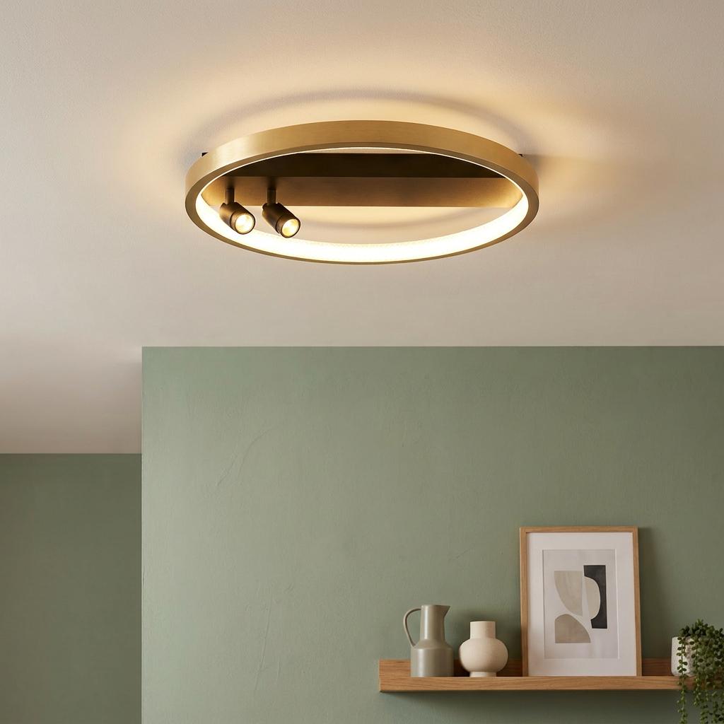 Gold and black circular flush LED ceiling light with two spotlights mounted above a sage green wall.
