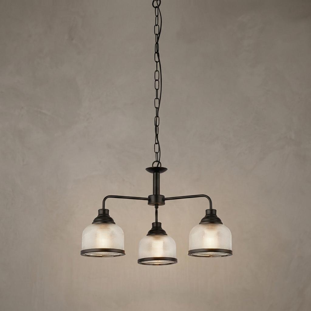 Three-light black pendant with ribbed glass shades hanging from a chain against a neutral background.