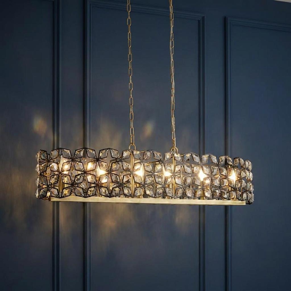 Searchlight Iris 6-light black, crystal, and brass rectangular pendant hanging against a dark blue paneled wall.