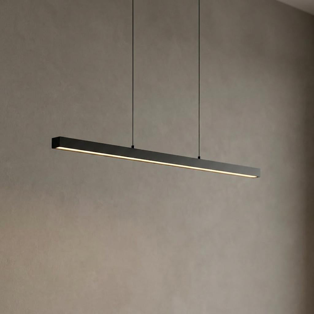 A minimalist black LED bar pendant light casting a warm glow against a textured neutral wall.