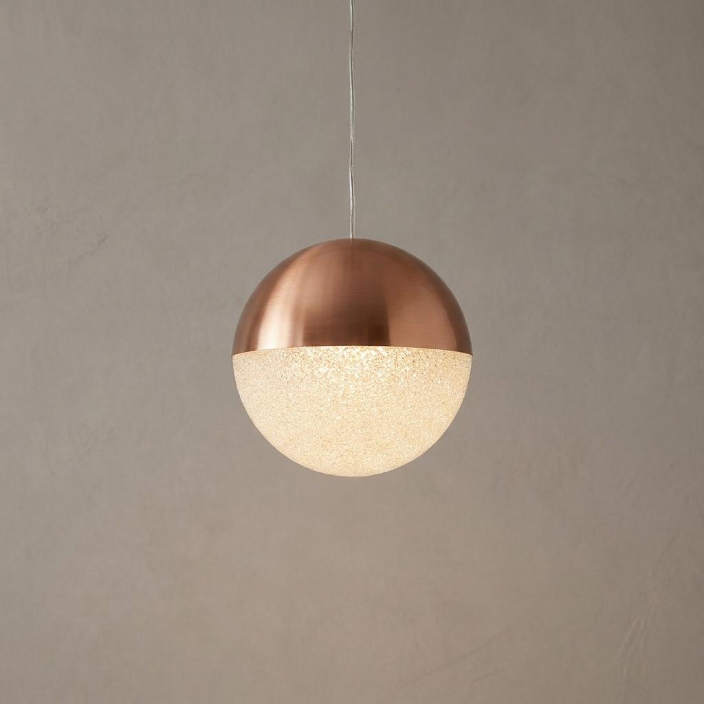 Spherical pendant light with a brushed copper top and a glowing crushed ice textured lower half.