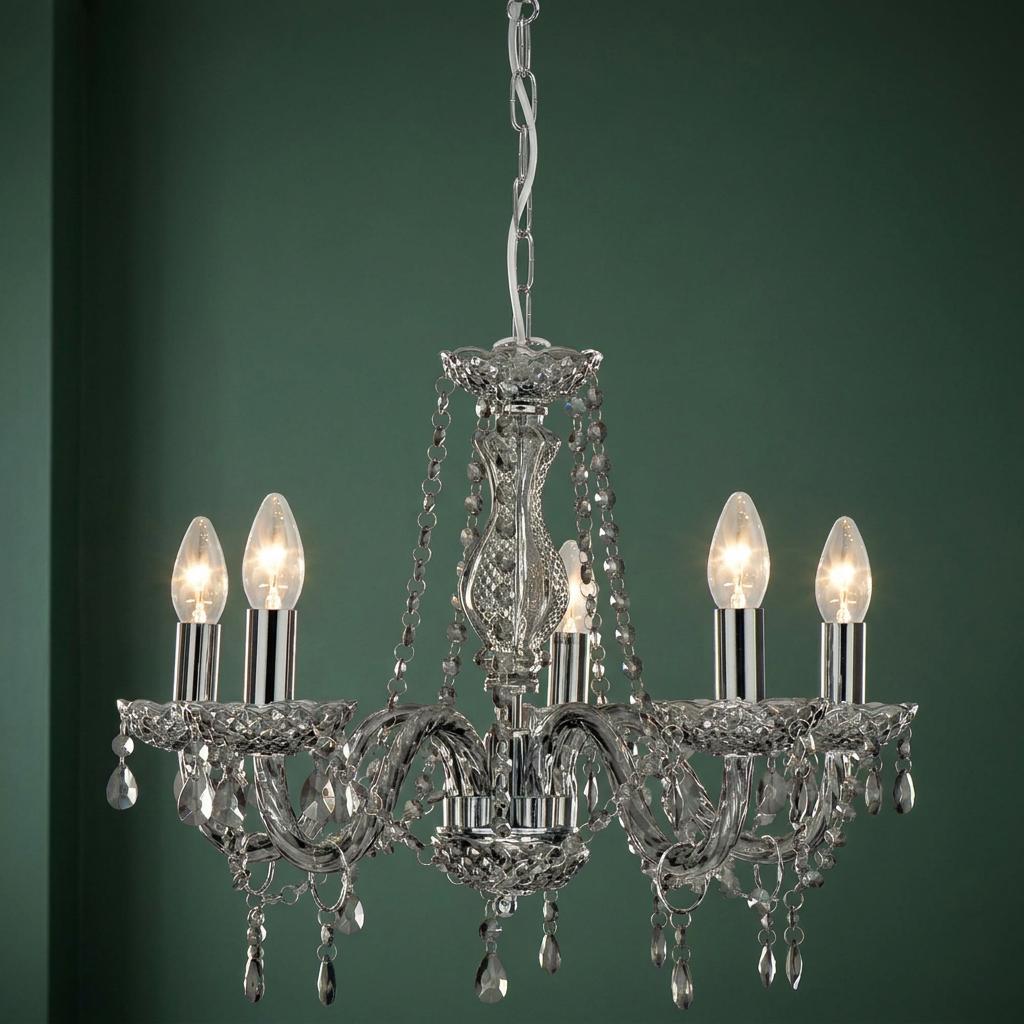 Marie Therese 5-light grey glass chandelier with crystals hanging against a dark green wall.