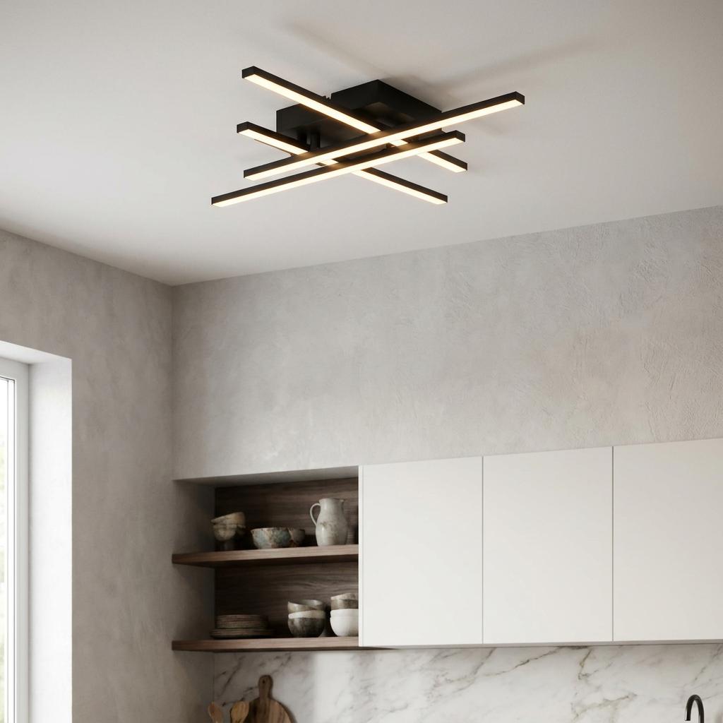 Modern black LED ceiling light with four intersecting bars illuminated in a contemporary kitchen.