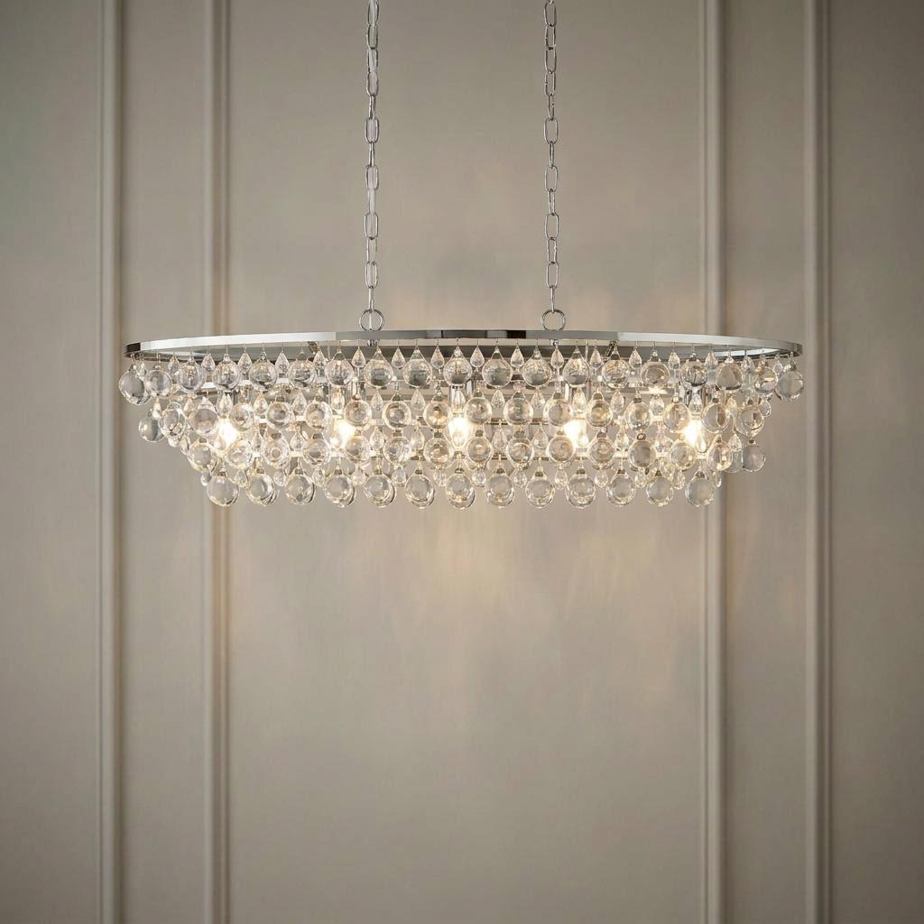 A chrome oval ceiling pendant with layered crystal droplets and five glowing bulbs against a panelled wall.