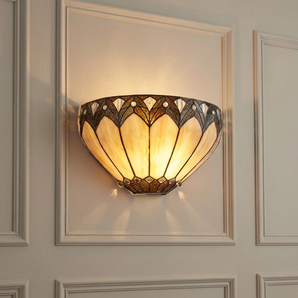 Illuminated Tiffany wall light with cream glass panels and decorative dark trim on a white paneled wall.