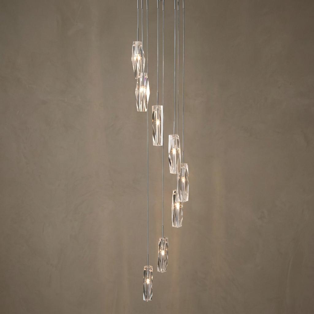 Multi-drop pendant light featuring cascading sculptured ice glass shades against a textured neutral background.