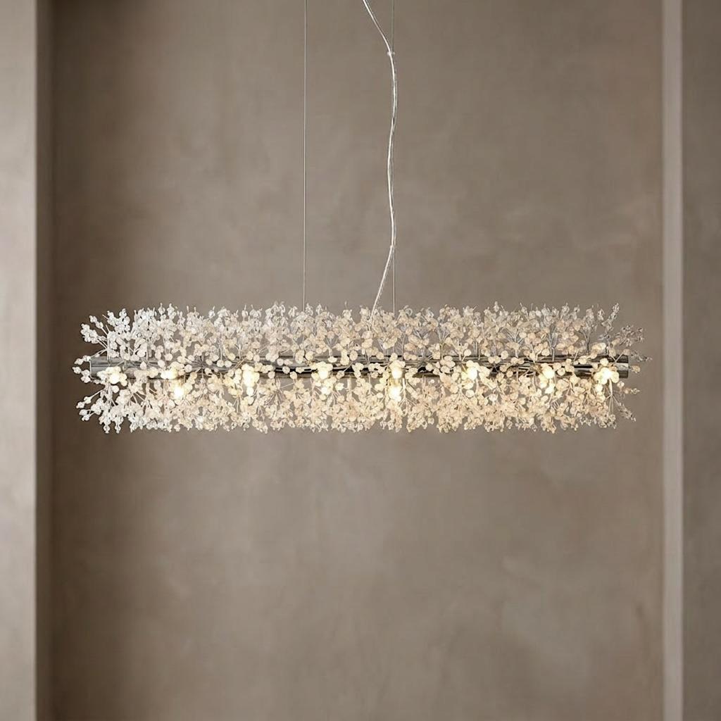 Modern chrome bar pendant fixture with a thick layer of shimmering glass beads hanging in a neutral interior.