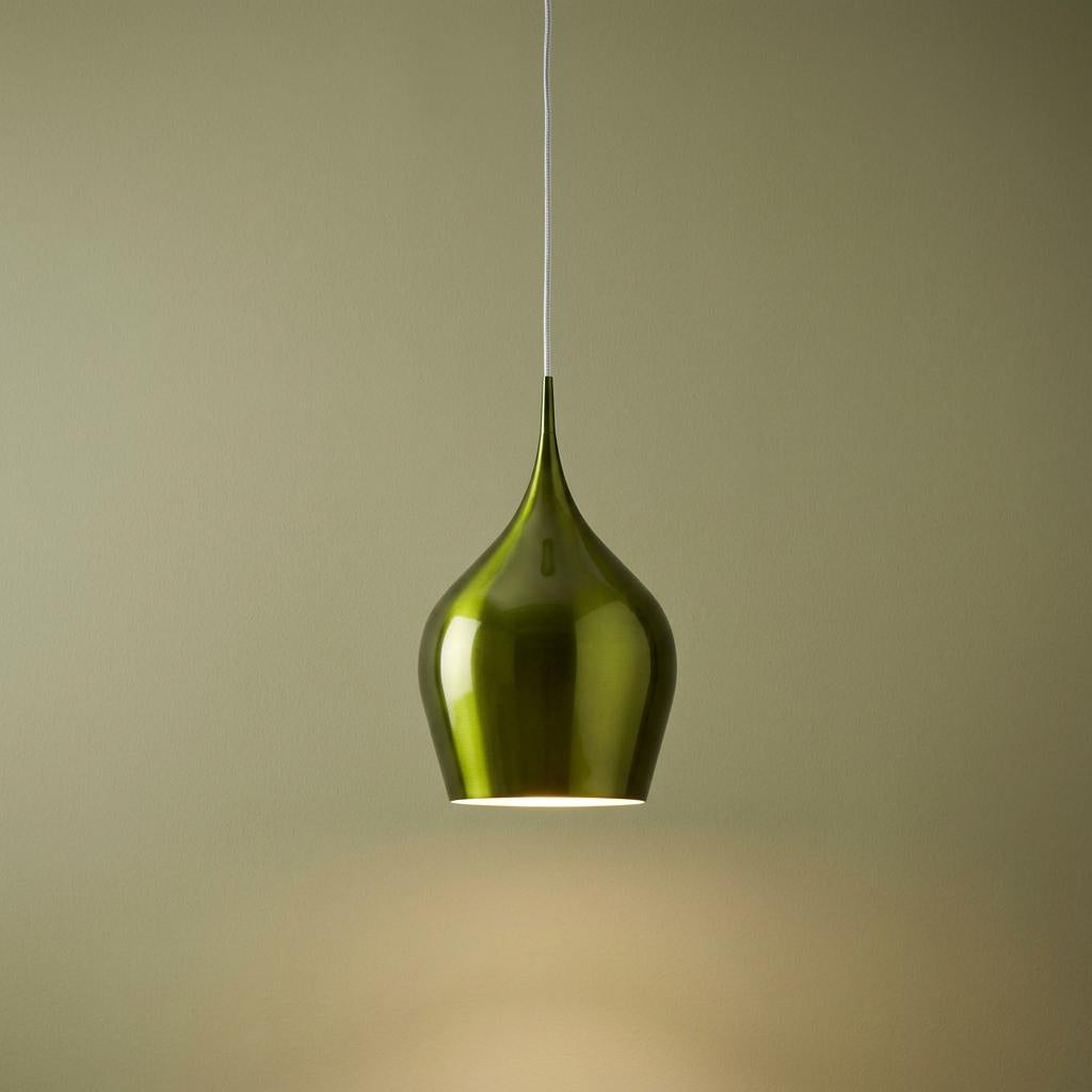 A glossy lime green teardrop pendant light suspended against a sage green background, emitting a soft downward light.