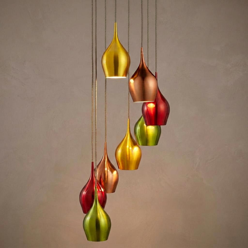 Eight colorful teardrop-shaped pendant lights in metallic gold, copper, red, and green hanging at varying heights.