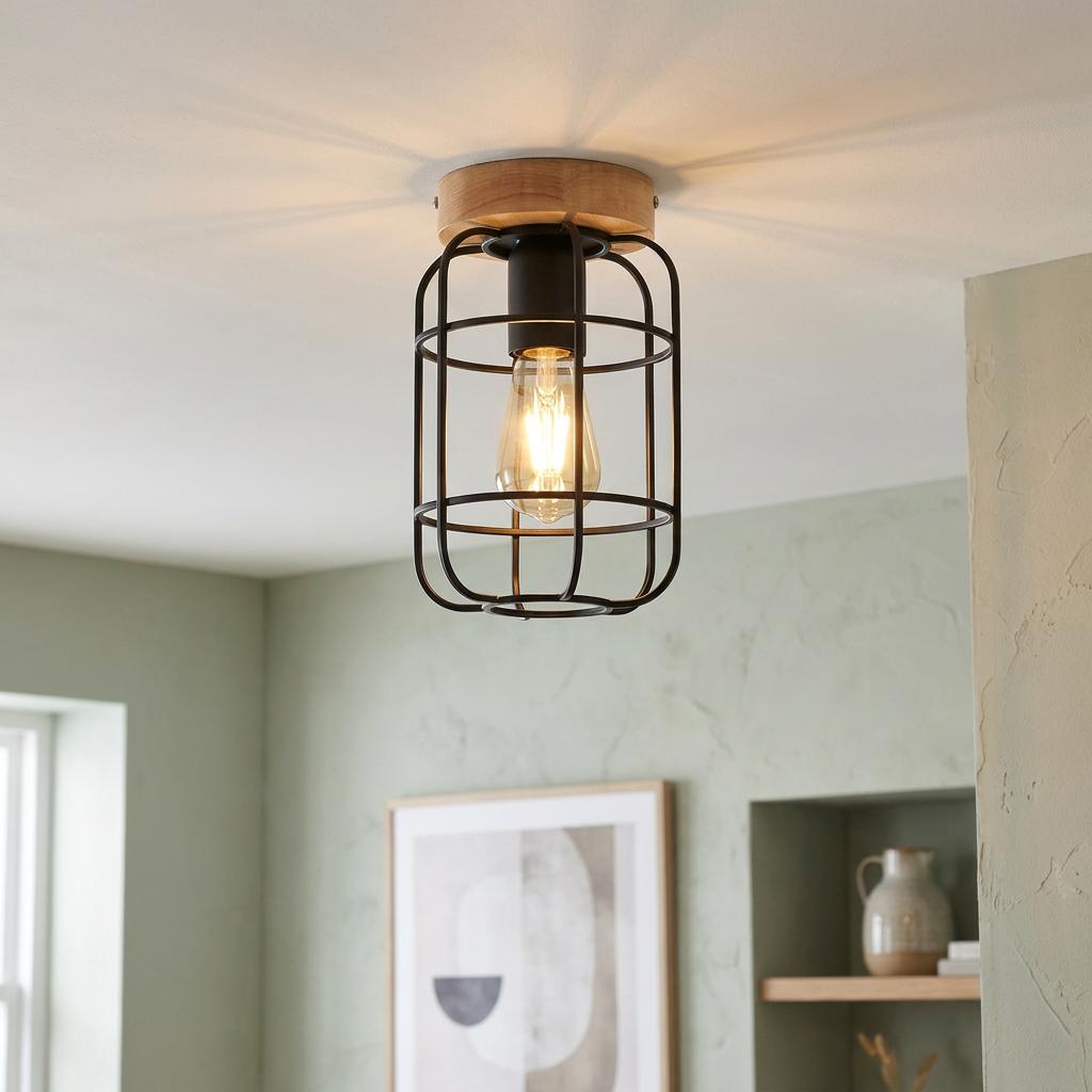 Industrial flush ceiling light with a black wire cage and wooden base, illuminating a sage green room.