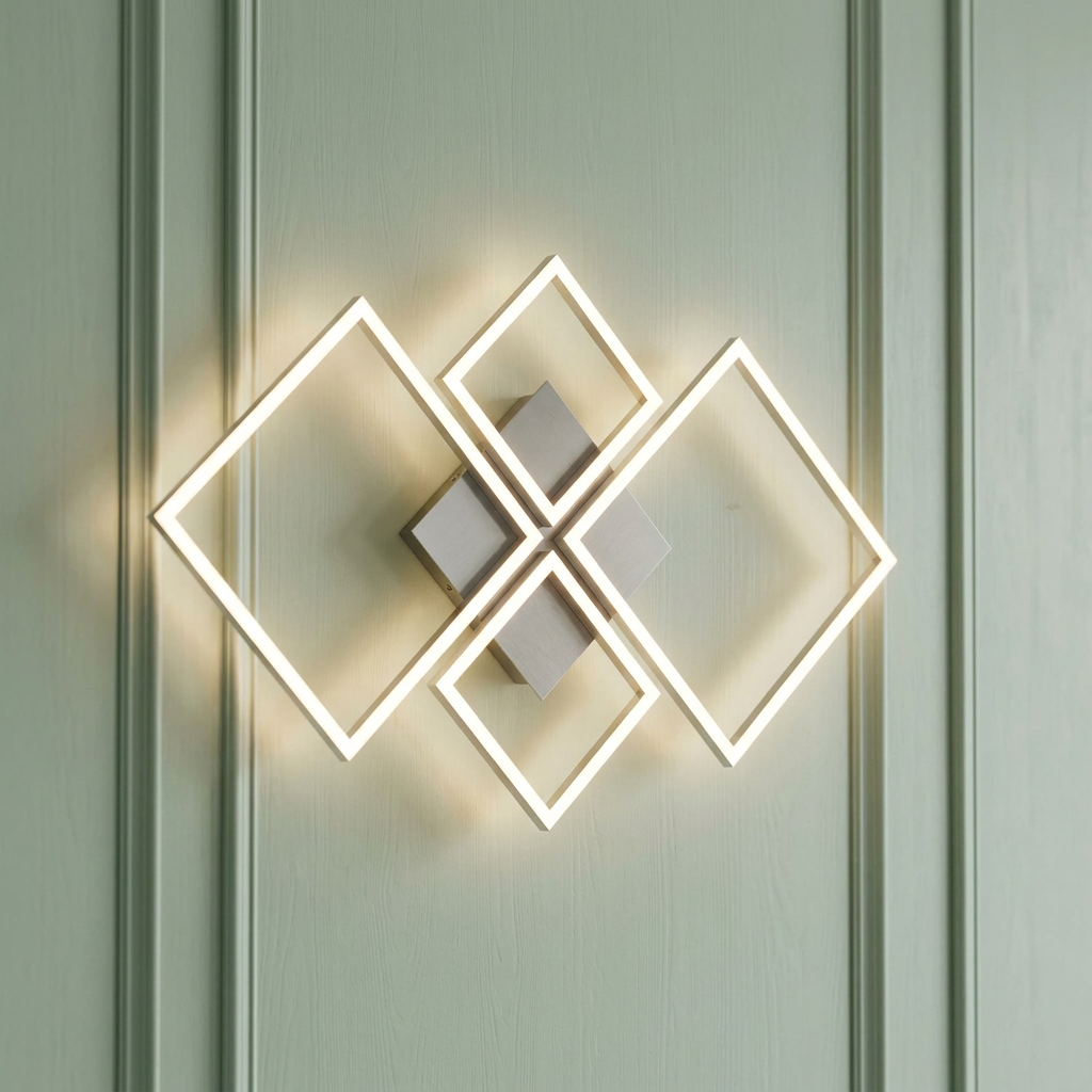 Four interlocking silver LED squares form a modern wall light on a sage green paneled wall.