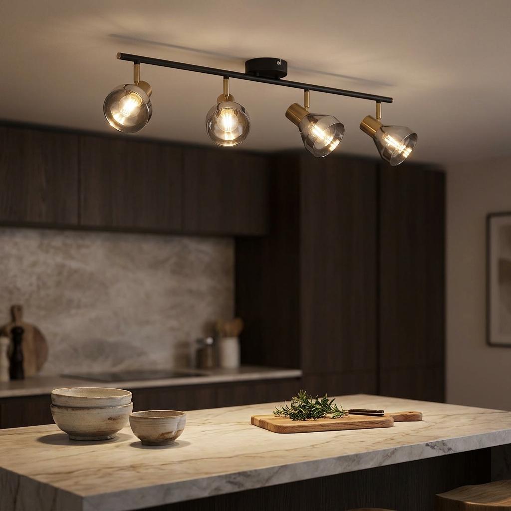 Four-light black and brass spotlight bar with smoked glass shades illuminating a modern kitchen island.