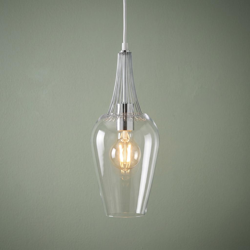 Chrome whisk-style ceiling pendant with a clear glass shade and lit bulb against a pale green wall.