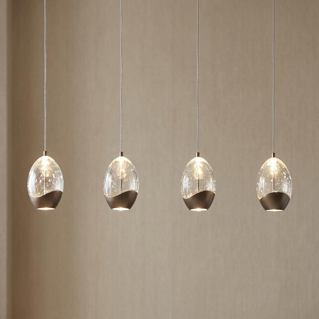 Four oval champagne bubbled glass pendants with latte metal bases hanging in a row against a beige wall.