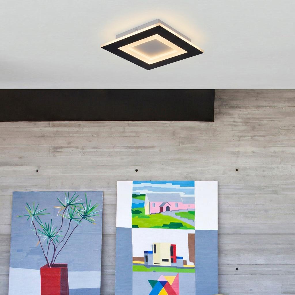 Squary LED square flush light in matt black mounted on a white ceiling above modern wall art.