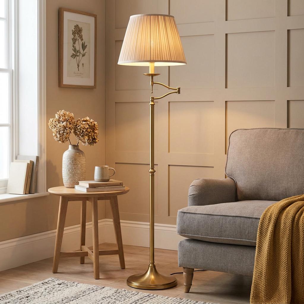 Antique brass swing arm floor lamp with a pleated shade standing next to a grey armchair in a cozy living room.