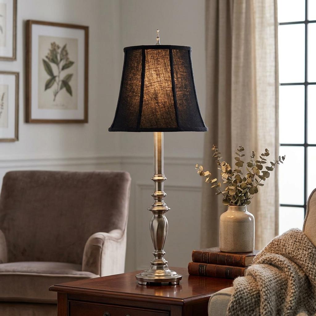 Stiffel Maine antique nickel table lamp with a black textured shade on a wooden table in a cozy living room.