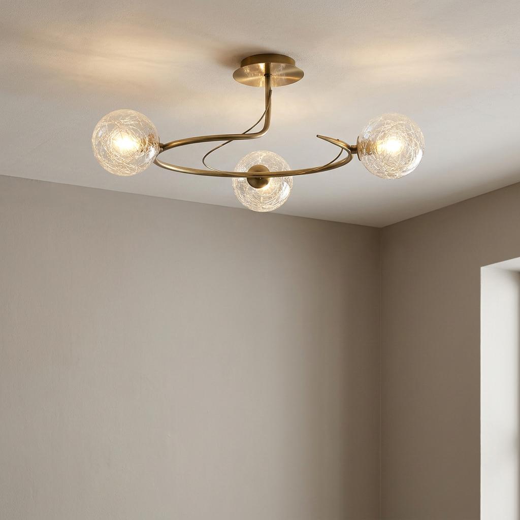 Antique brass ceiling light with three curved arms and textured glass globes illuminating a neutral-toned room.