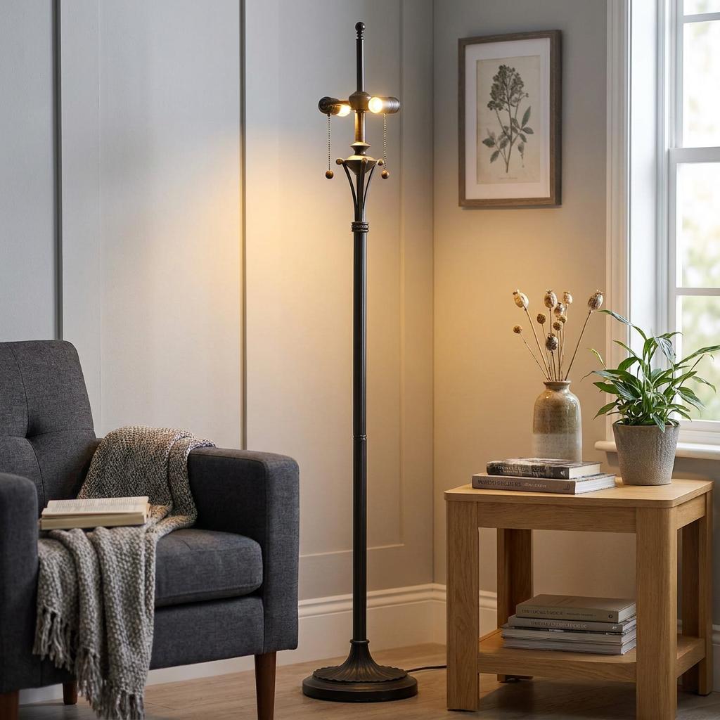 Bronze Tiffany floor lamp base with glowing bulbs standing in a cozy living room beside a grey armchair.