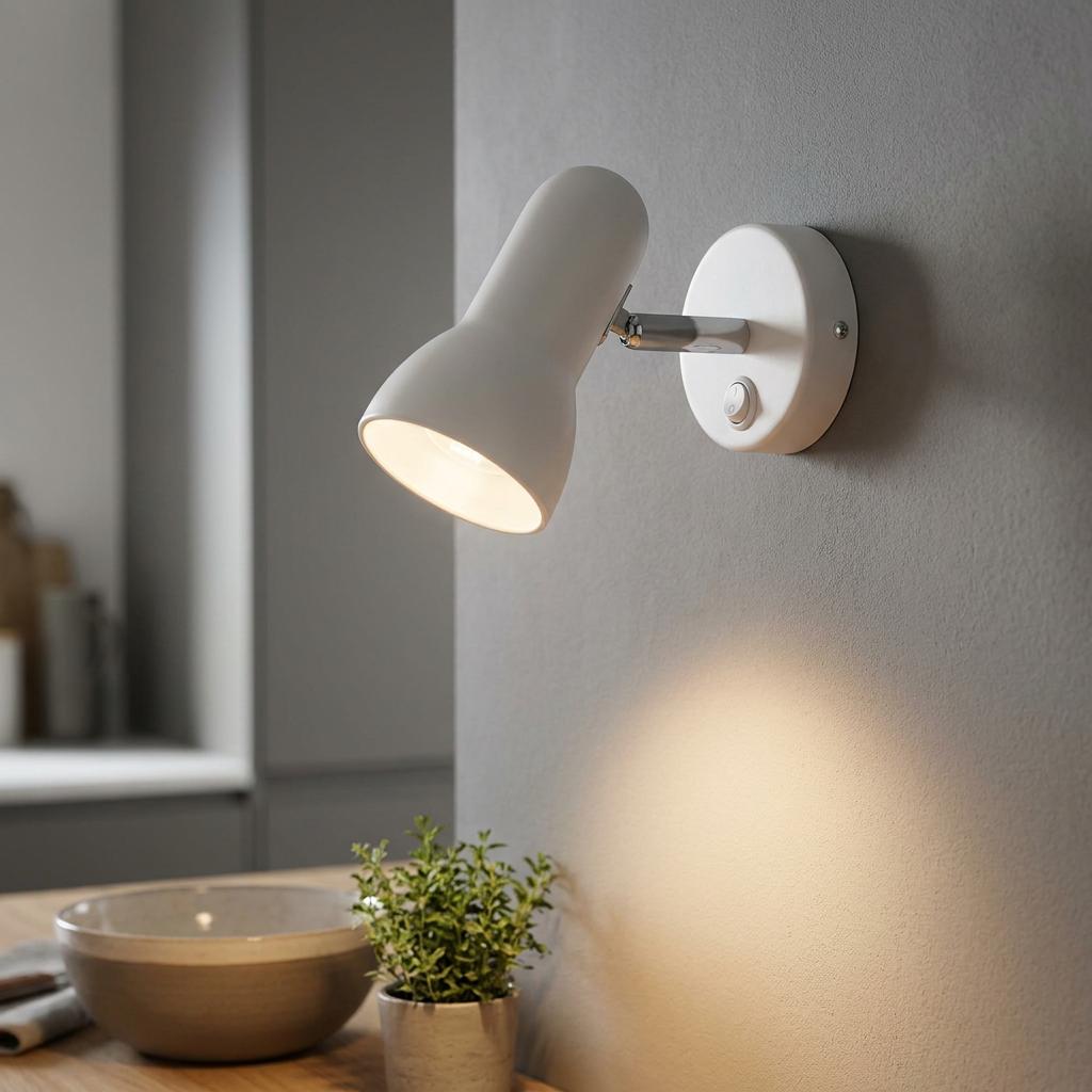 Satin white adjustable spotlight mounted on a grey wall, illuminating a wooden surface below.