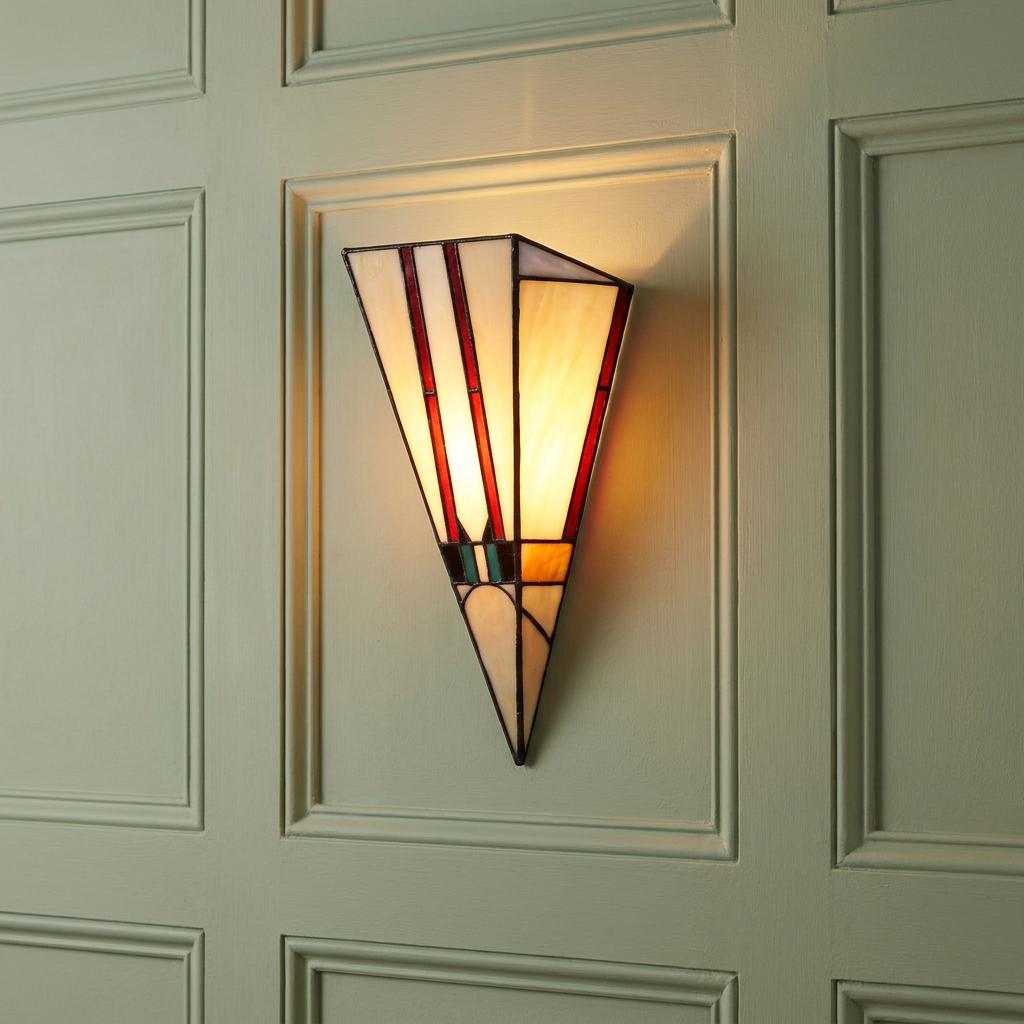 Geometric Art Deco Tiffany wall light with cream and red stained glass panels on a green paneled wall.