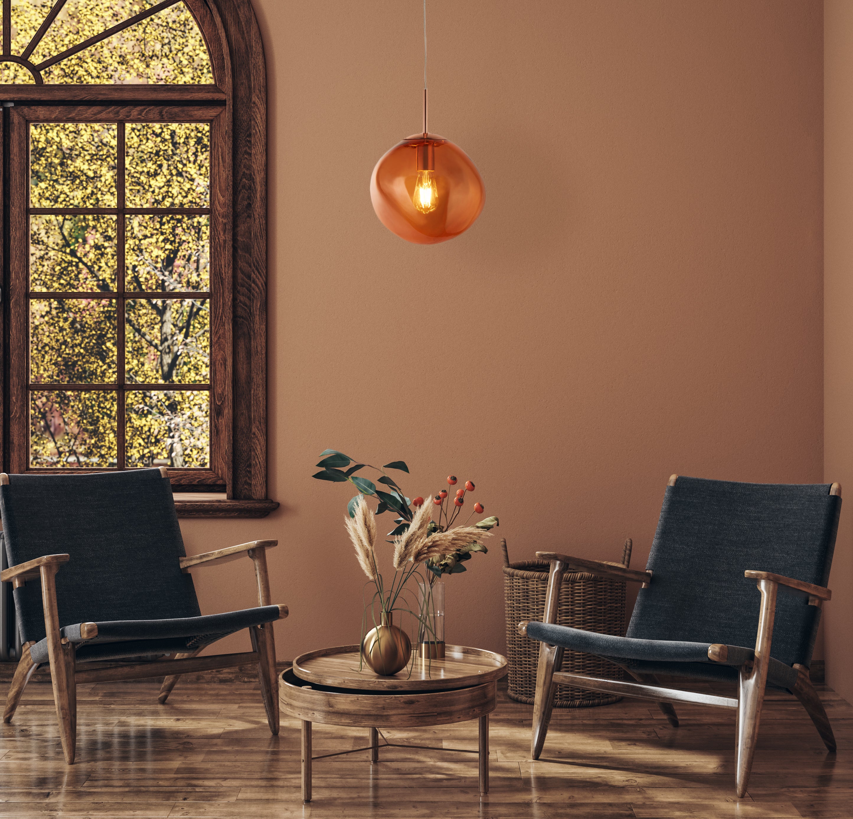 Modern living room with two dark blue chairs, a wooden table, and a hanging amber glass pendant light fixture.