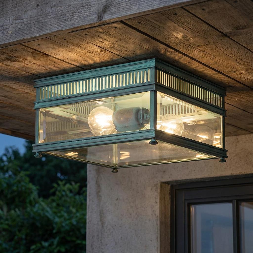 Verdigris-finished square glass ceiling lantern mounted on a wooden overhang, illuminated at dusk.