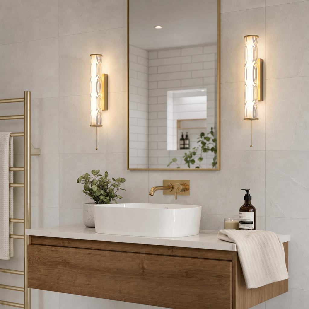 Two gold LED wall lights with rippled glass flank a mirror above a modern bathroom vanity.