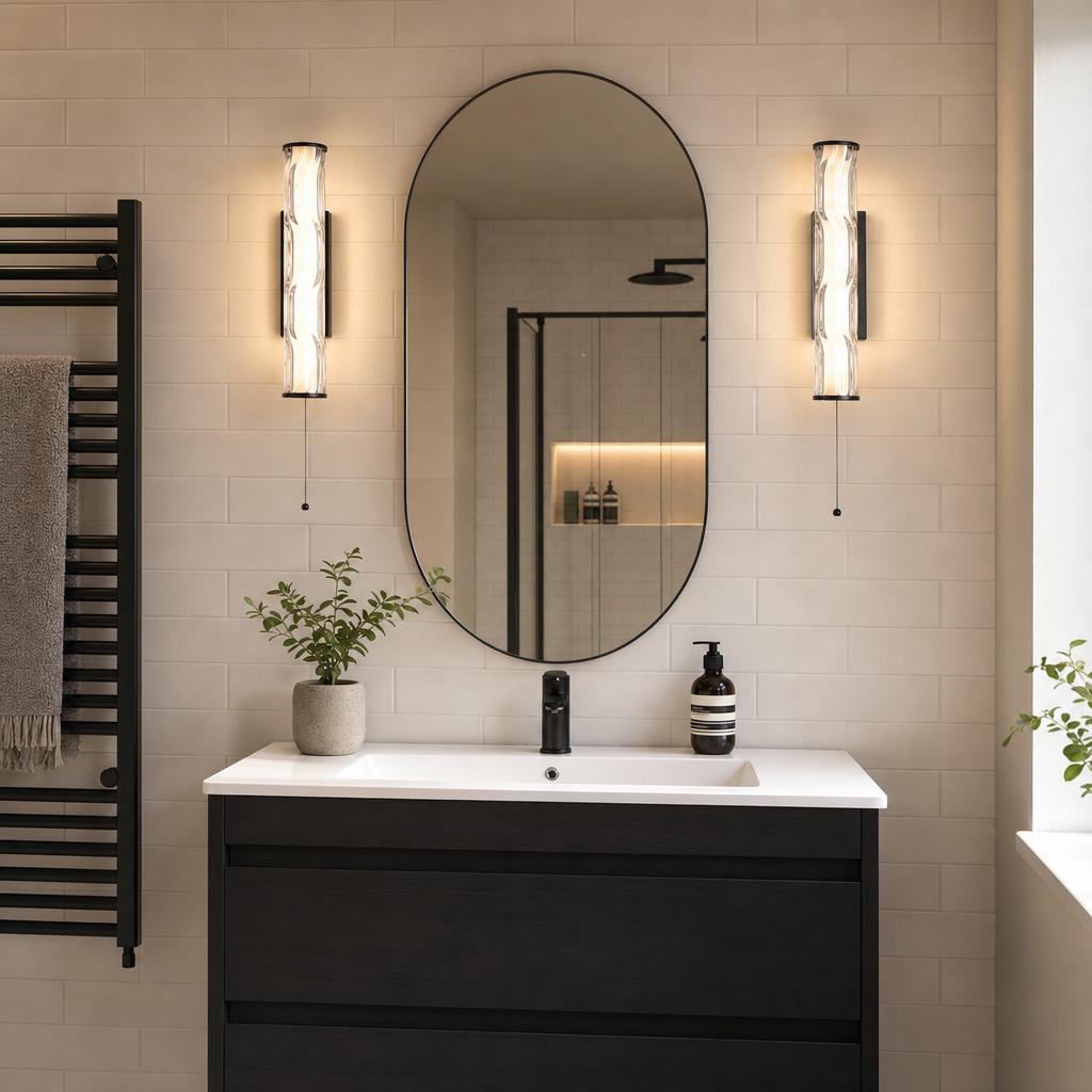 Two Vibrate matt black LED wall lights with textured glass flanking an oval mirror in a modern bathroom.