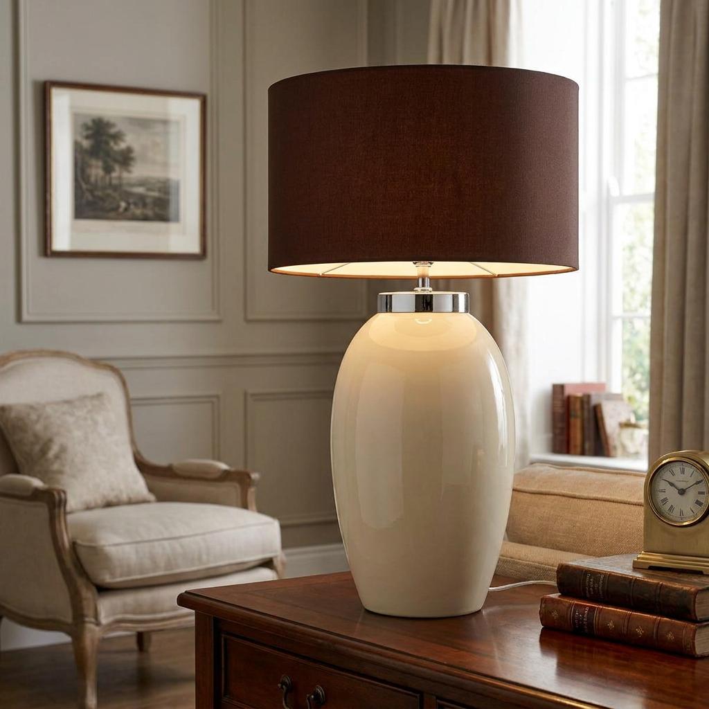 Victor Large cream ceramic table lamp with a brown drum shade sitting on a wooden desk.
