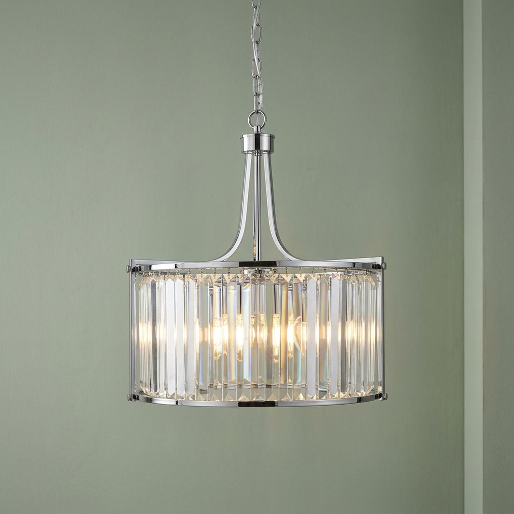 Victoria 5 light chrome and crystal glass drum ceiling pendant illuminated against a sage green wall.
