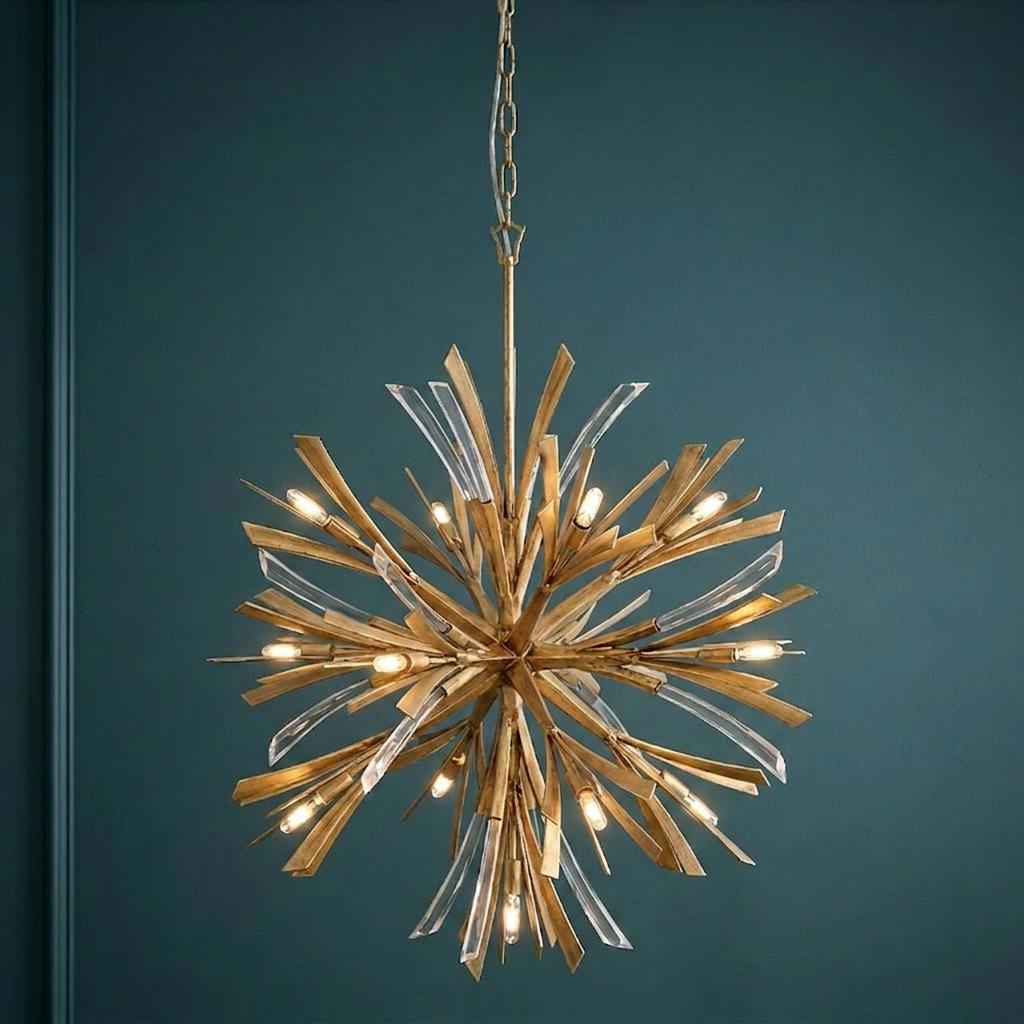 Vida 13-light gold starburst chandelier with crystal details hanging against a dark blue wall.